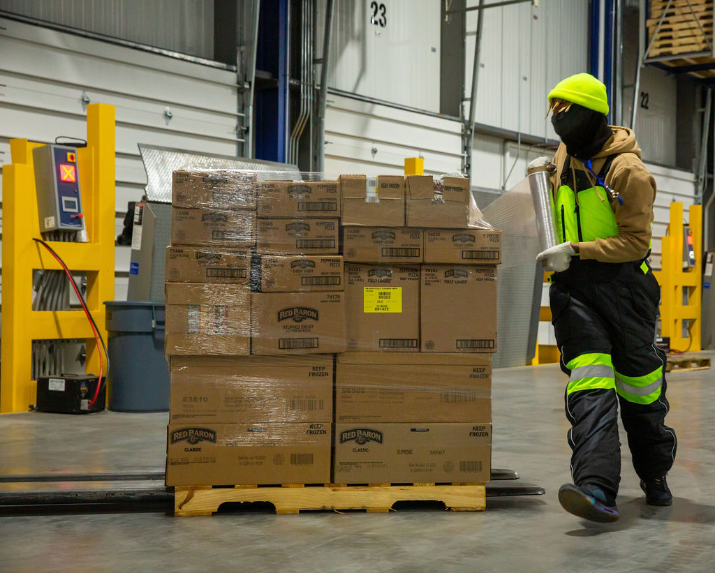 Cold storage dock employee working on wrapping a pallet of product at FlexCold-Jacksonville, FL.